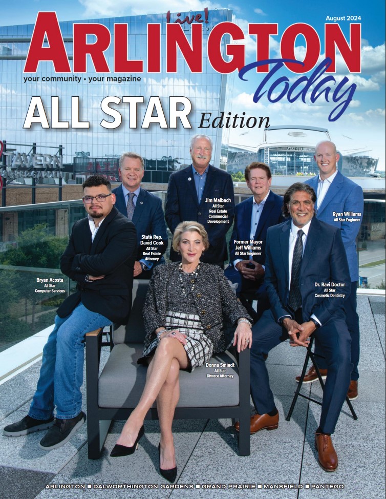 The August 2024 cover of Arlington Today magazine, titled "ALL STAR Edition." The cover features a group of seven professionals posing outdoors in front of a modern glass building. The individuals are identified as prominent figures in various industries, including real estate, engineering, dentistry, law, and technology. Dr. Ravi Doctor, labeled as a cosmetic dentist, is seated on the right wearing a dark suit and smiling. Donna Smiedt, a divorce attorney, sits in the center wearing a stylish black-and-white outfit with high heels. Other individuals, including State Representative David Cook, Jim Malsach, former Mayor Jeff Williams, Ryan Williams, and Bryan Acosta, are standing behind them. The background features the Arlington cityscape, including a domed stadium. The magazine highlights community leaders and professionals in Arlington, Texas.