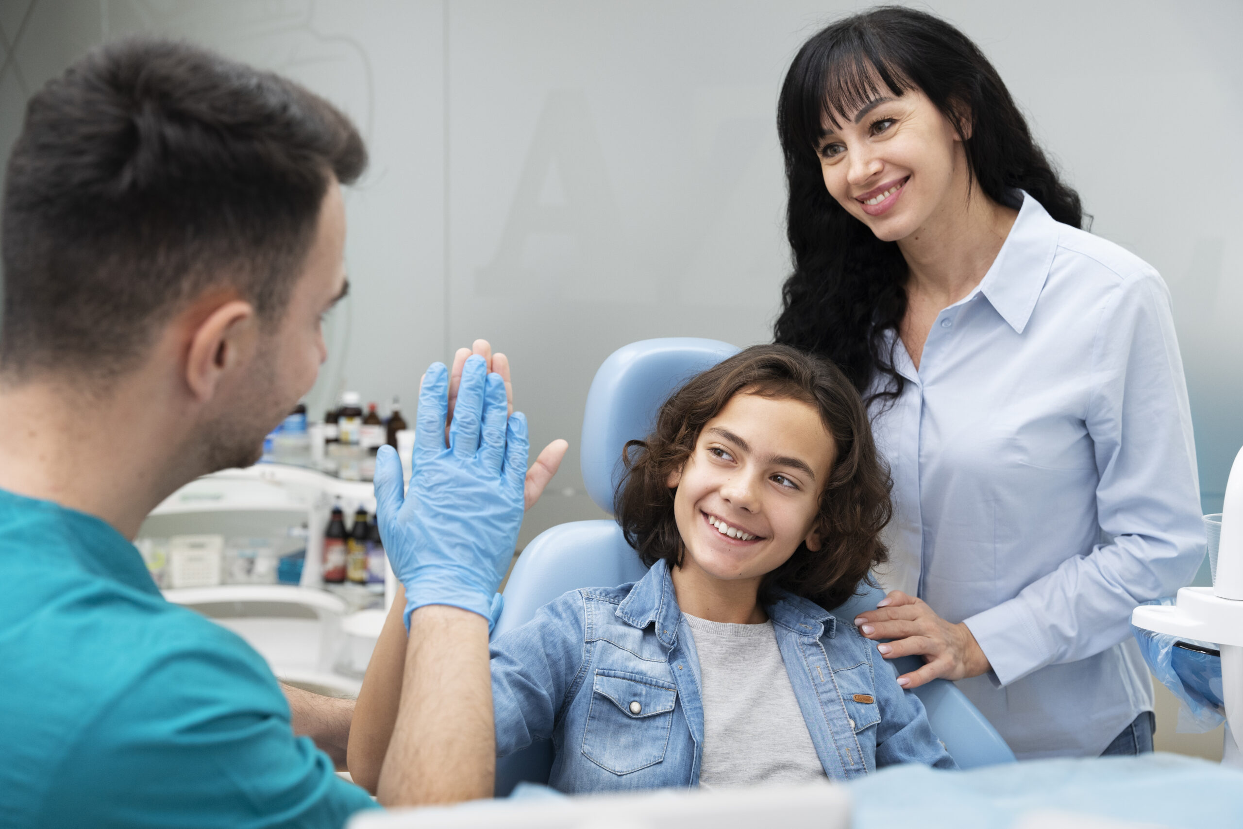 Dentist giving a high five to a child patient during a dental visit.